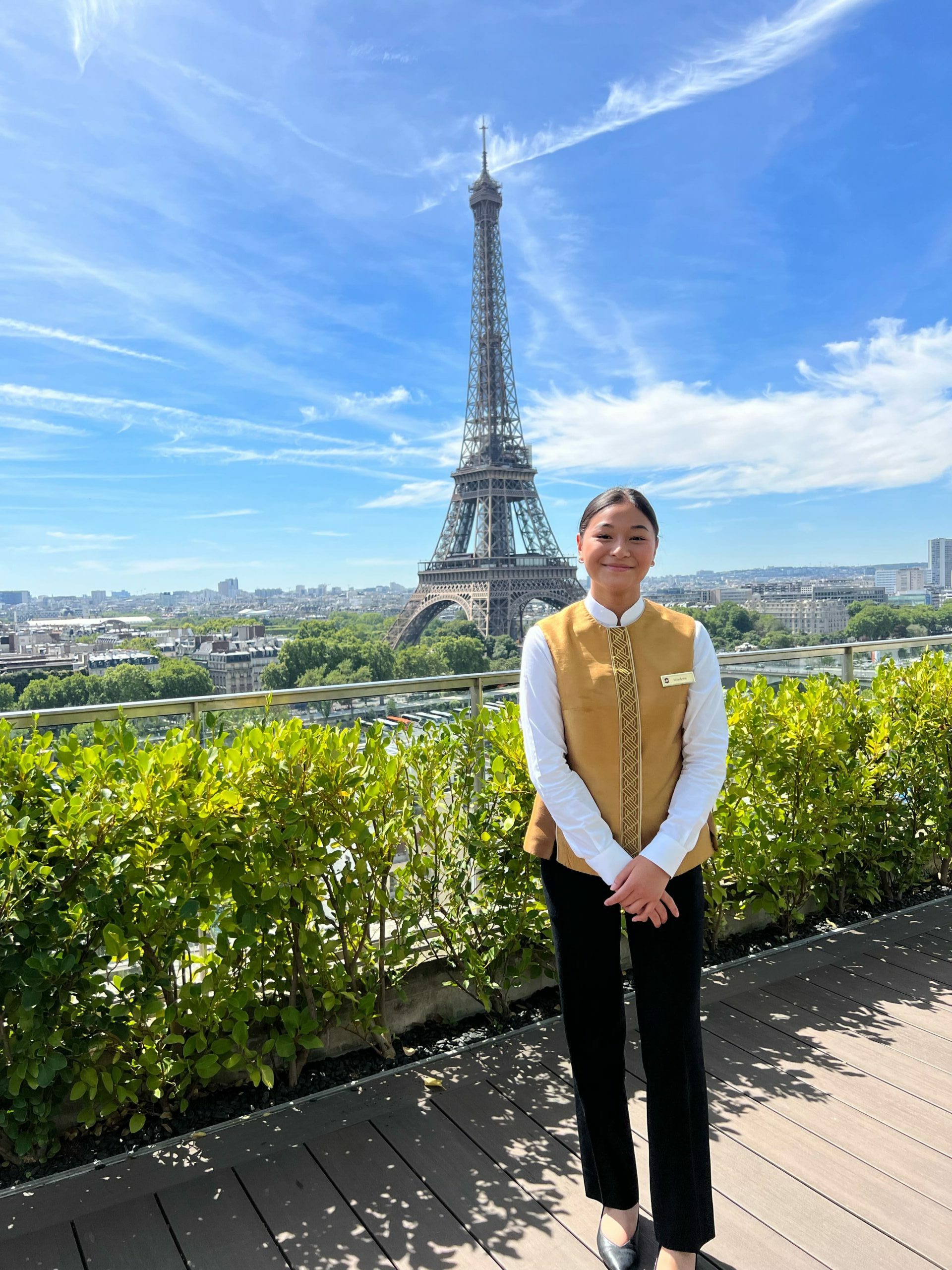 Photo d'une étudiante d'une école hôtelière devant la tour Eiffel - Luxury Hotelschool