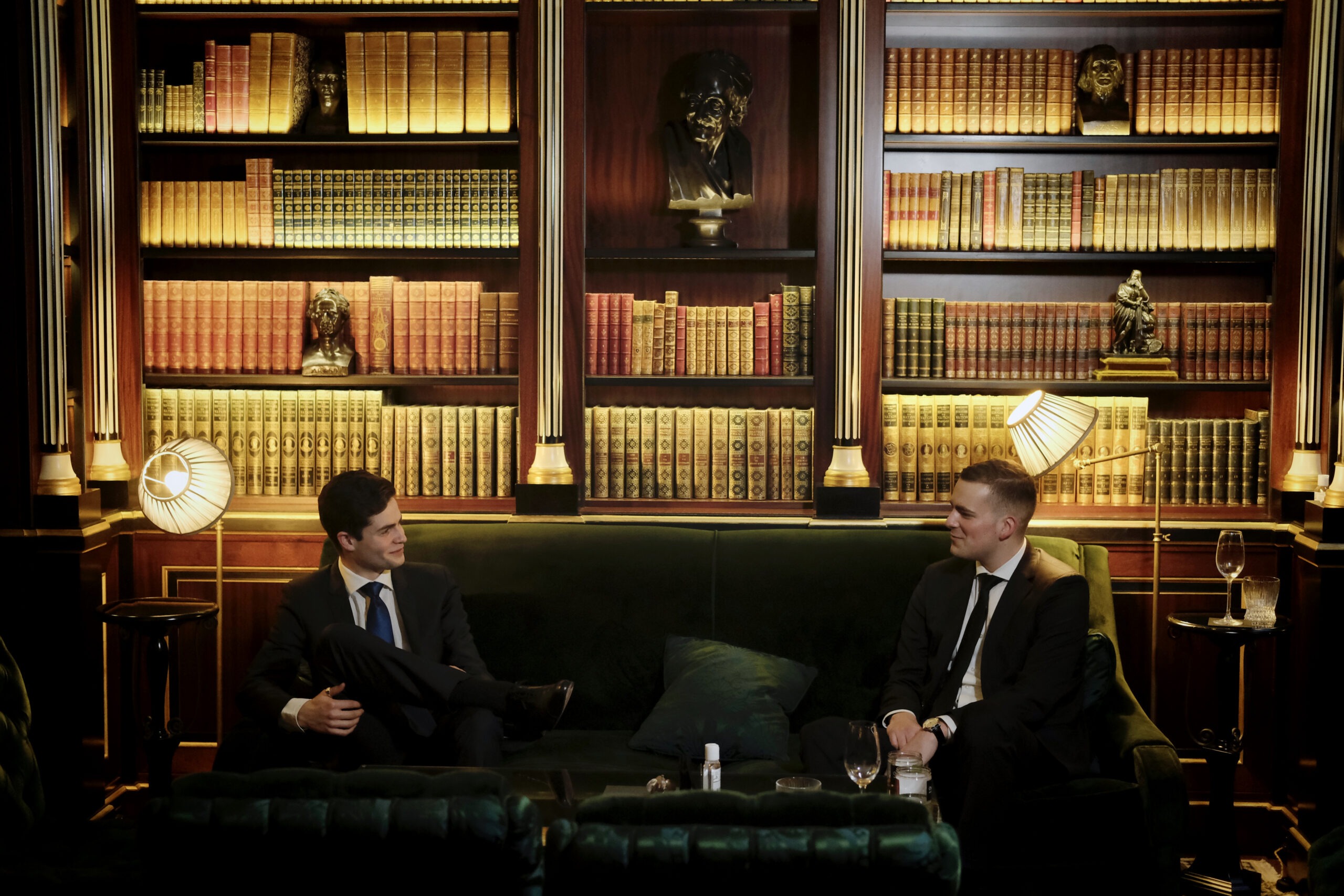 Deux hommes dans une bibliothèque assis sur un canapé - Luxury Hotelschool