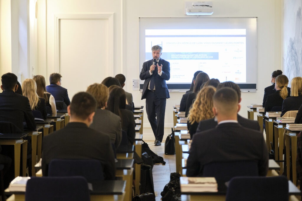 Photo d'un professeur avec un micro dans les mains qui parlent à des étudiants - Luxury Hotelschool