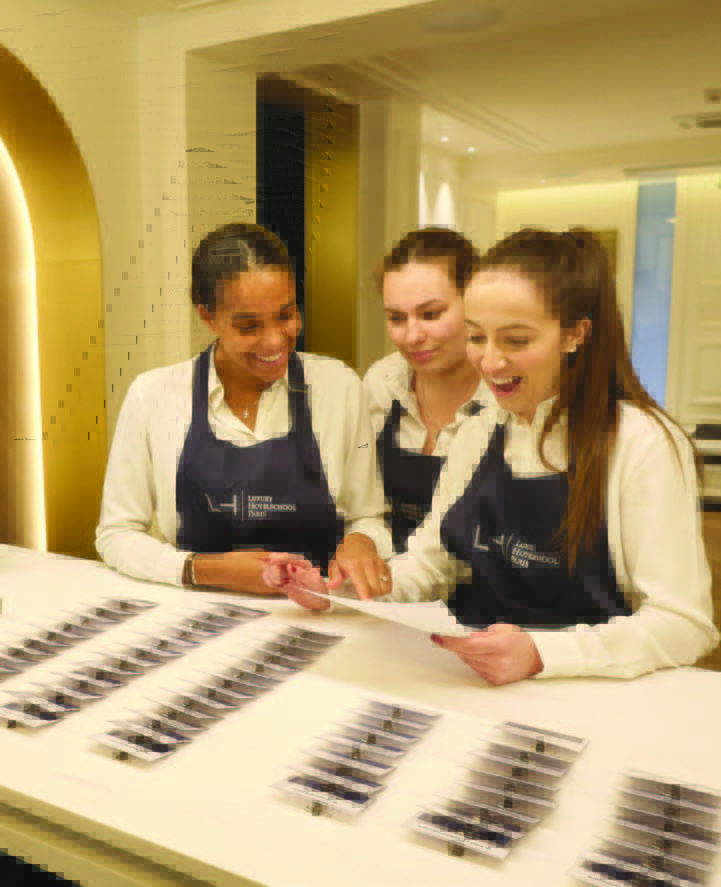 Photo de trois étudiantes qui lisent un document - Luxury Hotelschool