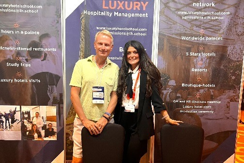 Photo d'un homme et d'une femme derrière un stand - Luxury Hotelschool