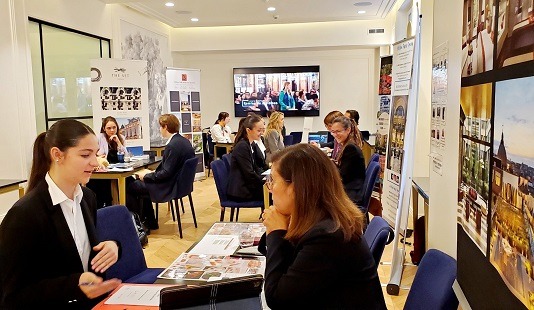 Personnes assises autour de plusieurs tables pour un forum sur les métiers de l'hôtellerie - Luxury Hotelschool