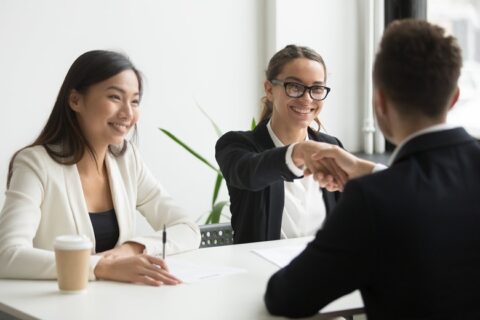 businessman-shaking-hand-female-coworker-company-meeting-min